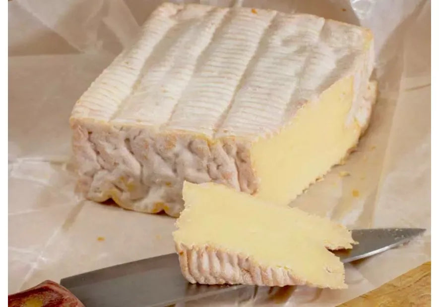 queso Pont l'Évêque AOP cortado en triángulos sobre tabla de madera