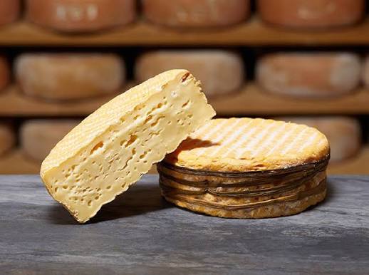 Queso Livarot AOP de Normandía con sus tiras de totora, entero y cortado