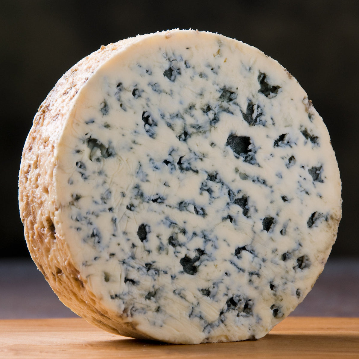 Fourme d'Ambert cortada con vetas azules frente a los Montes del Forez